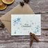 A Christmas greeting card with blue snowflakes and the words &