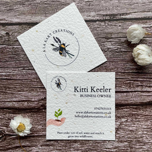 square plantable seed paper business cards with a sustainable future design featuring a hand holding a growing seedling, from a la kart creations