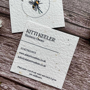 square plantable seed paper business cards with wildflower seeds, angled right showing a closeup of the custom information, from a la kart creations