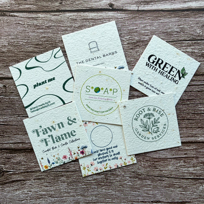 Collection of branded square plantable seeded business cards on a wooden surface