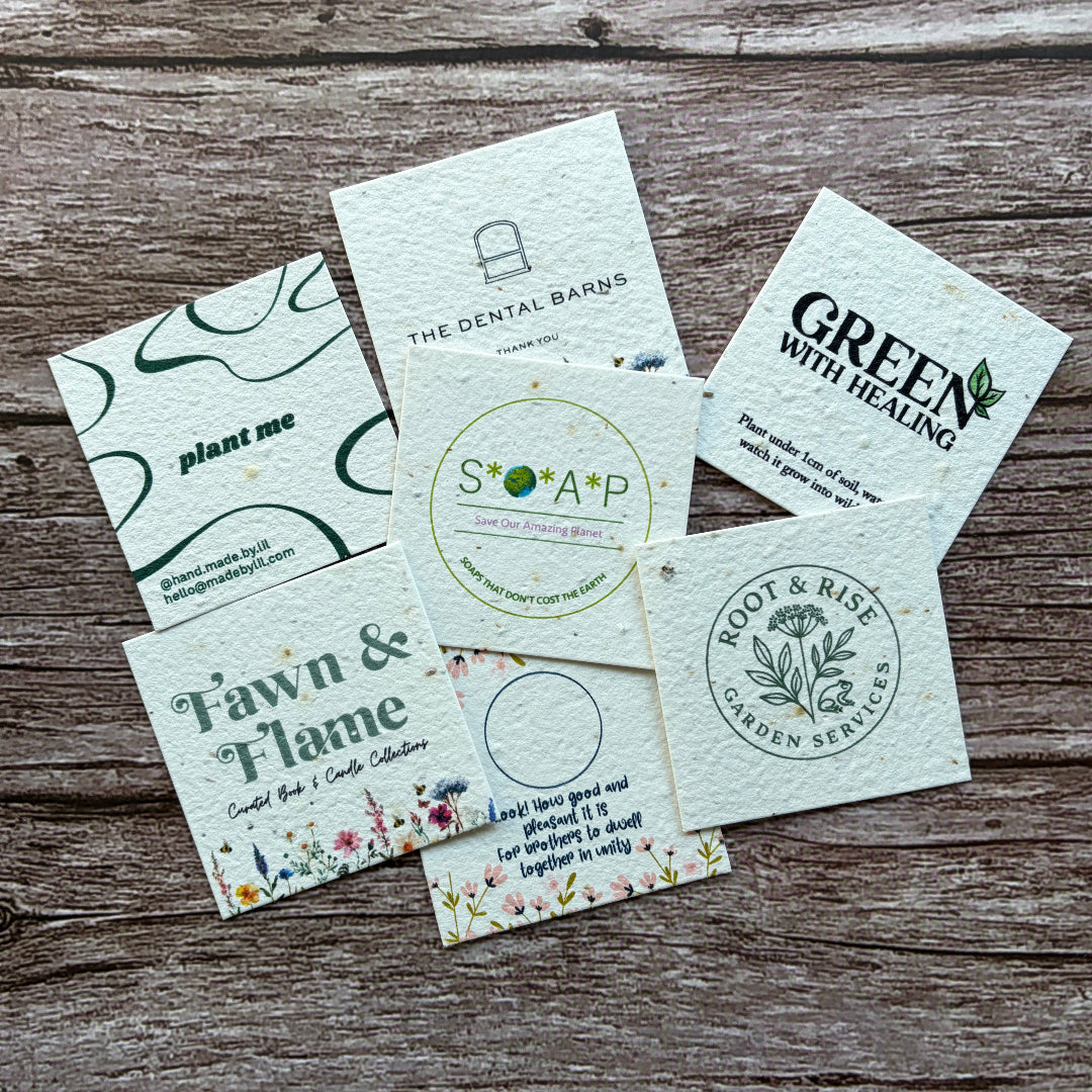 Collection of branded square plantable seeded business cards on a wooden surface