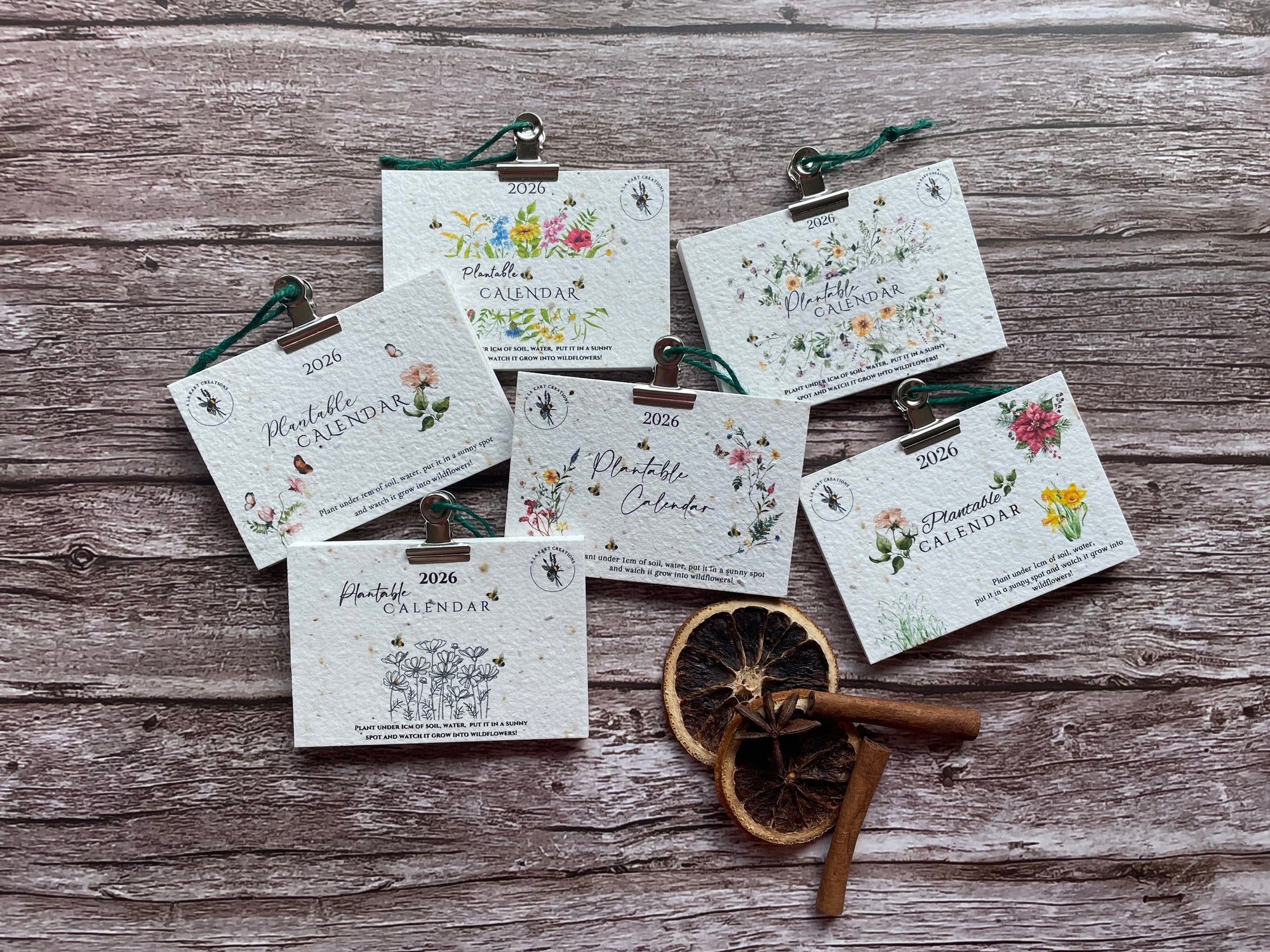 Small 2026 plantable calendars with floral designs on a wooden surface