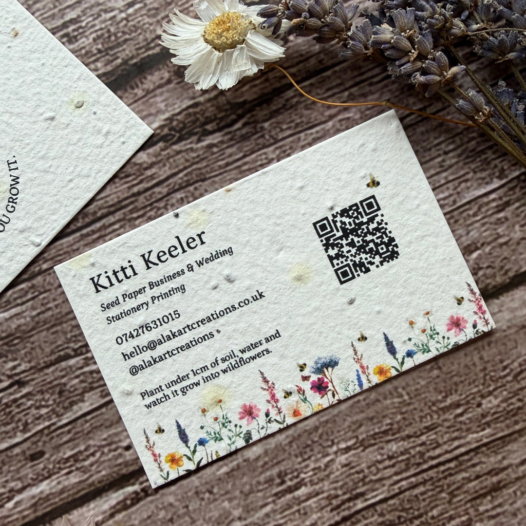 Floral business card with QR code on a wooden surface with dried flowers.