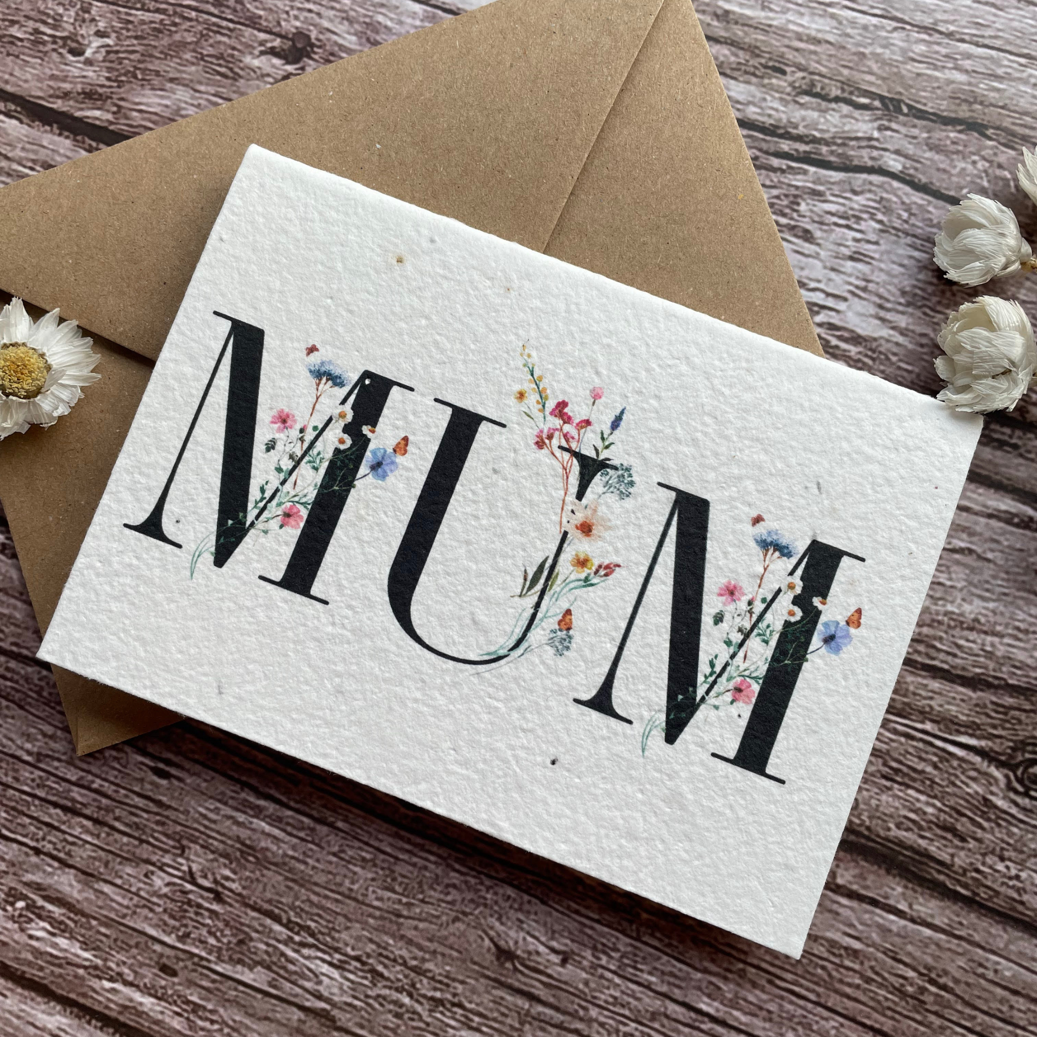 angled left view of personalised plantable mother's day card with wildflowers entwined with "mum", handmade from seed paper