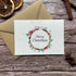 plantable Christmas card with wreath design on a wooden background