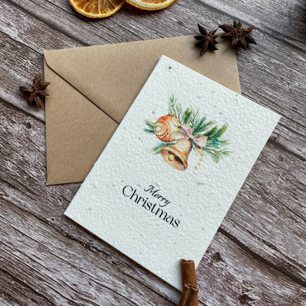 plantable Christmas card with golden bells on a wooden background