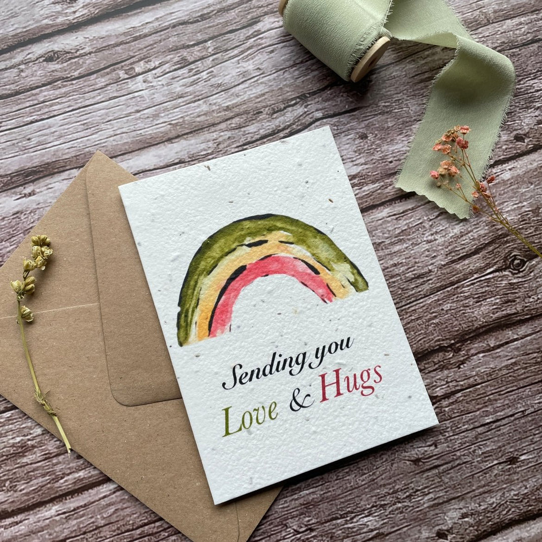 Angled left view of the Love &amp; Hugs Rainbow Personalised Plantable Card highlighting the cheerful design.