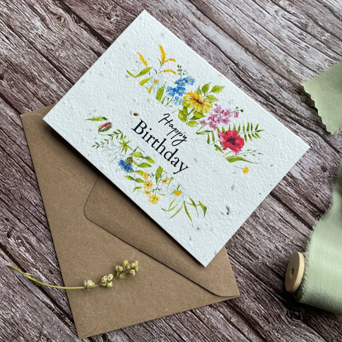 left angled view of personalised wildflower foliage plantable birthday card with wildflower border and vibrant colours