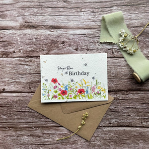 personalised wildflower meadow plantable birthday card with vibrant wildflower design and buzzing bees overhead