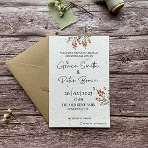 personalised plantable wedding invitations, burnt orange theme, front view with eco-friendly brown kraft envelope, floral design on wooden background