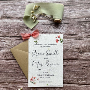 personalised plantable wedding invitations in sweet pea theme, front view with eco-friendly brown kraft envelope, floral design on wooden background