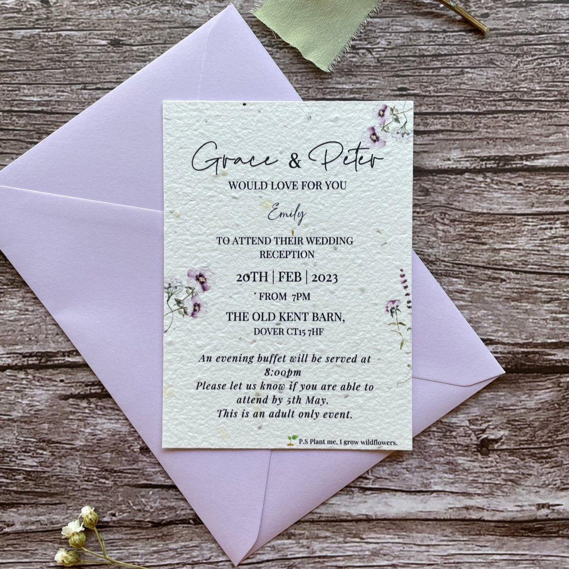 plantable evening guest wedding invitations in lilac theme, showing front view with colour matched envelope, floral design on wooden background