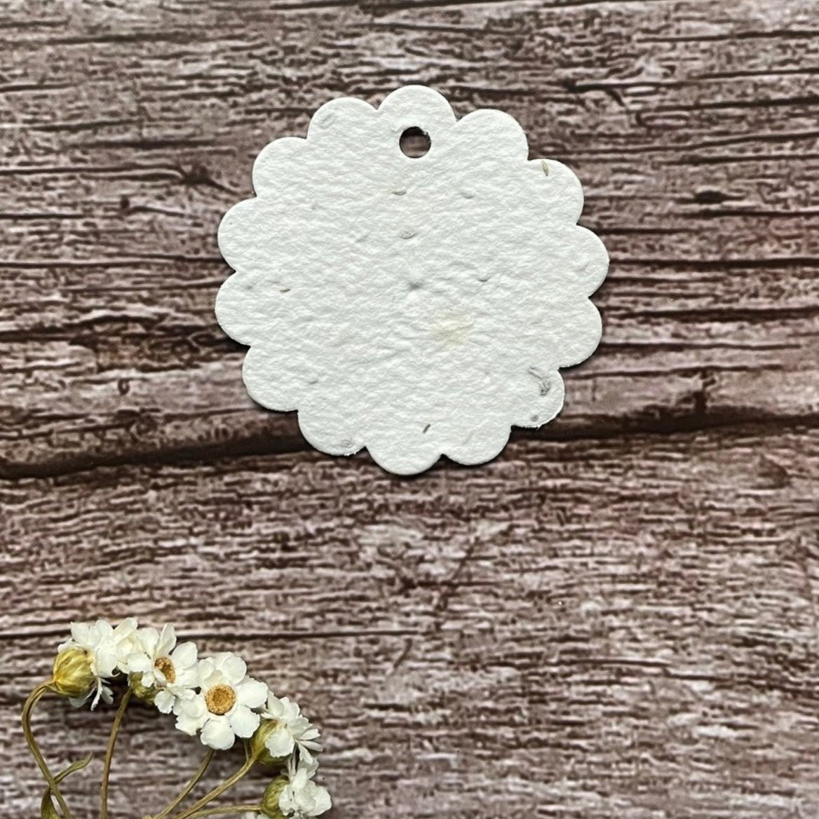 plantable seed paper tag flower shaped on wooden surface