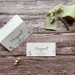 plantable seed paper wedding guest place cards in lilac theme, showing flat and standing views, floral design on wooden background, eco-friendly