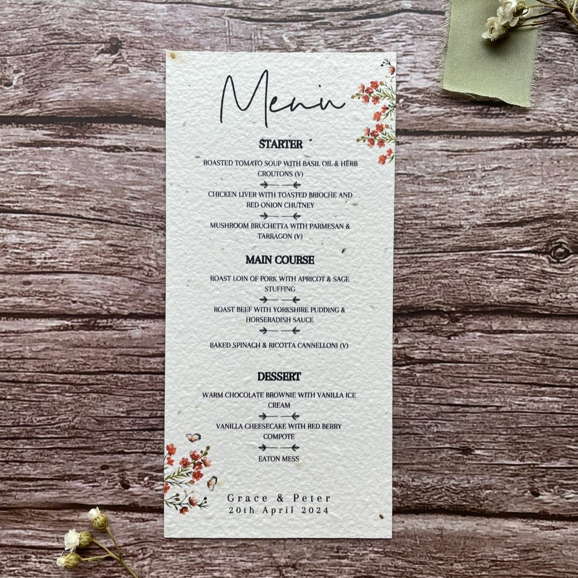 plantable seed paper wedding menu card in burnt orange theme, showing a close-up front view, floral design on wooden background, eco-friendly