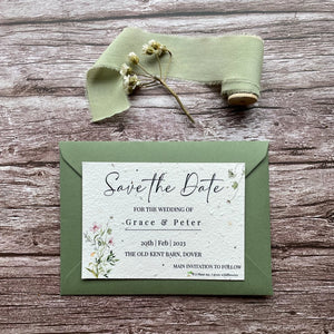 plantable seed paper wedding save the date card in spring green theme, shown with theme colour matched envelope, floral design on wooden background