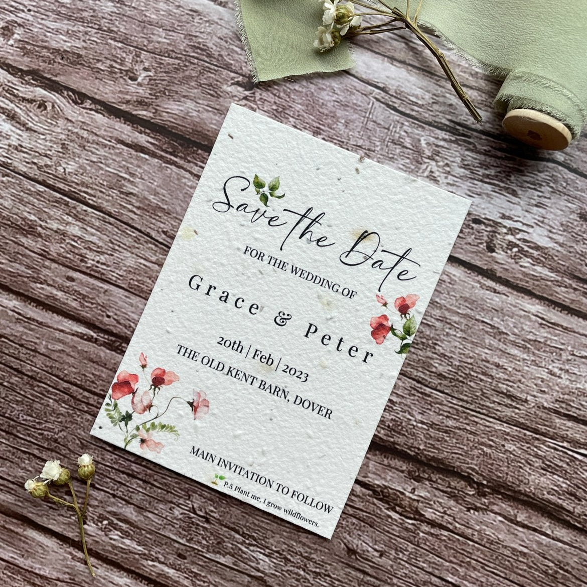 plantable seed paper wedding save the date cards in sweet pea theme, angled view with floral design on wooden background, eco-friendly, alakartcreations