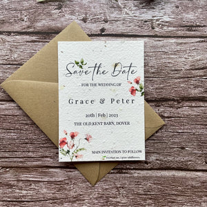 plantable seed paper wedding save the date cards in sweet pea theme, front view with eco-friendly brown kraft envelope, floral design on wooden background, alakartcreations