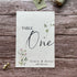 plantable seed paper wedding table number/name card with a botanical showing front view, floral design on wooden background