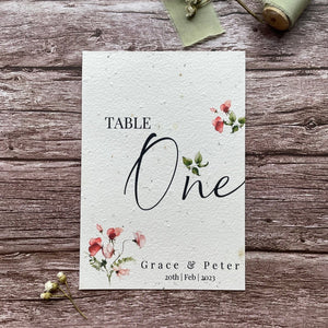 plantable seed paper wedding table number or name cards in sweet pea theme, front view with floral design on wooden background, eco-friendly, alakartcreations