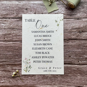 plantable seed paper wedding table seating plan in botanical theme, showing front view, floral design on wooden background, eco-friendly