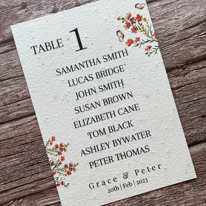 plantable seed paper wedding table seating plan in burnt orange theme, angled left view with floral design on wooden background, eco-friendly, alakartcreations