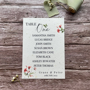 plantable seed paper wedding table seating plan in sweet pea theme, showing front view, floral design on wooden background, eco-friendly