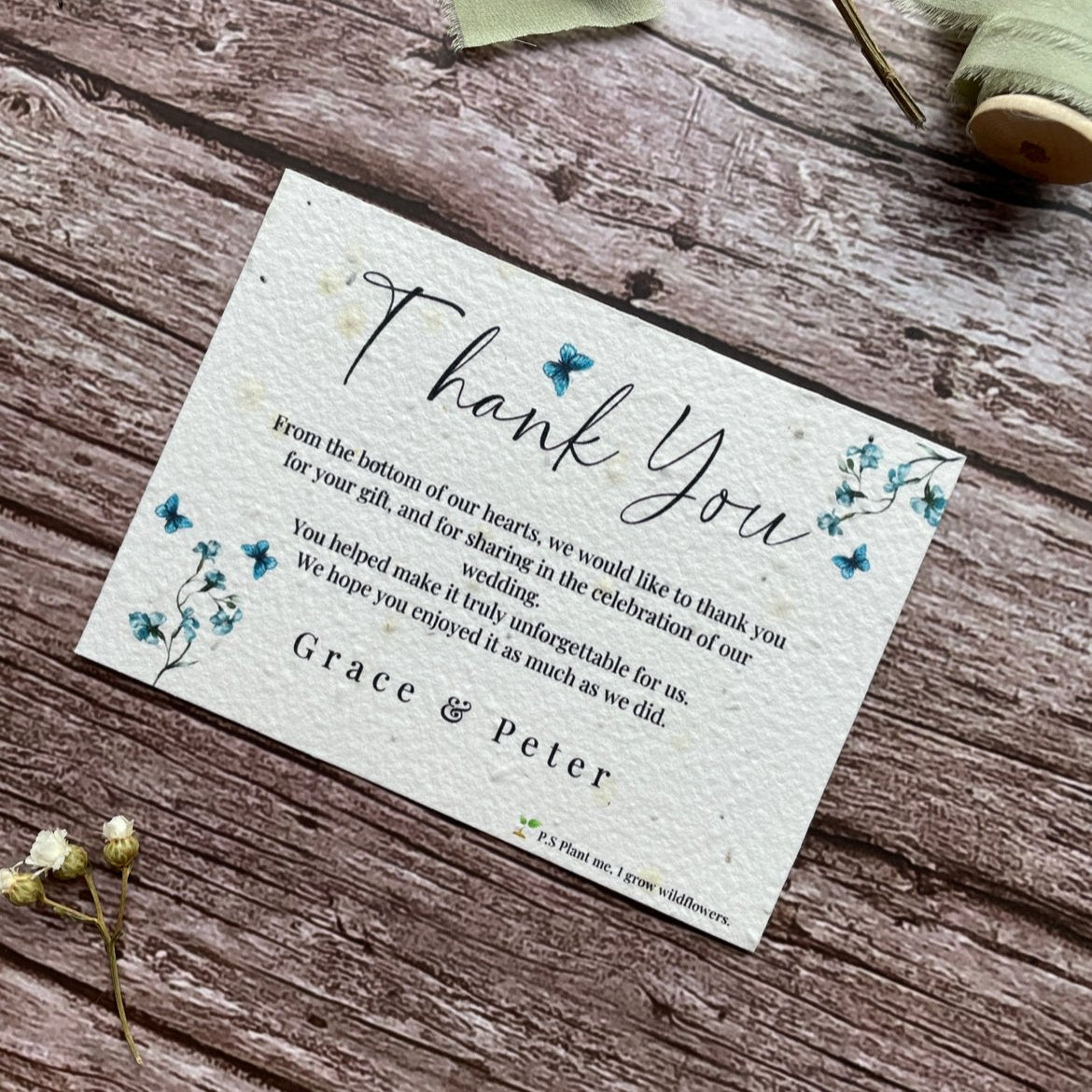 plantable seed paper wedding thank you cards with blue sweet peas design , angled on wooden background