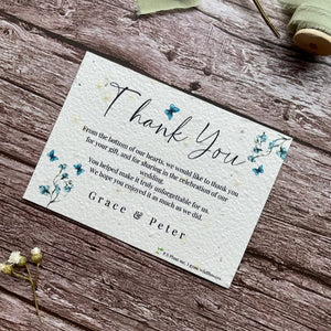 plantable seed paper wedding thank you cards with blue sweet peas design , angled on wooden background