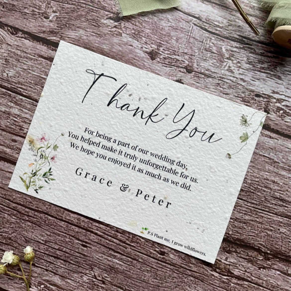plantable seed paper wedding thank you cards with a botanical design angled view with floral design on wooden background