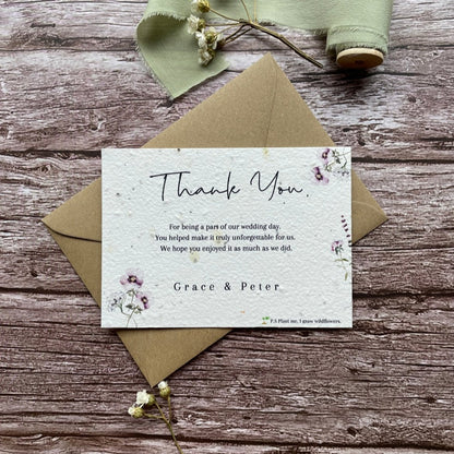 plantable seed paper wedding thank you cards in lilac theme, front view with eco-friendly brown kraft envelope, floral design on wooden background, alakartcreations