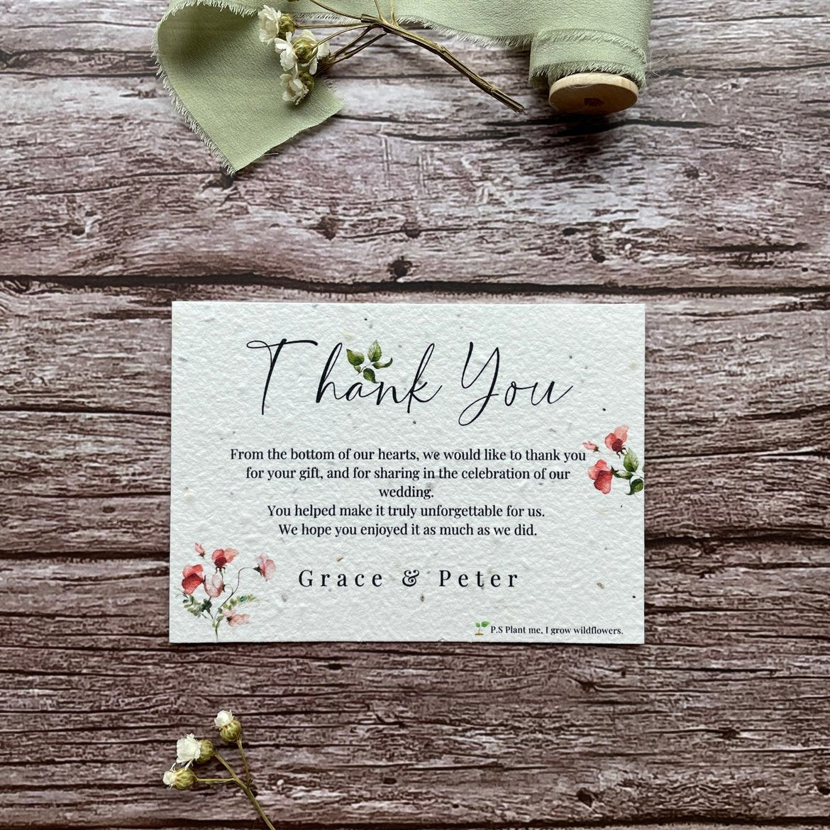 plantable seed paper wedding thank you cards in sweet pea theme, showing angled view, floral design on wooden background, eco-friendly