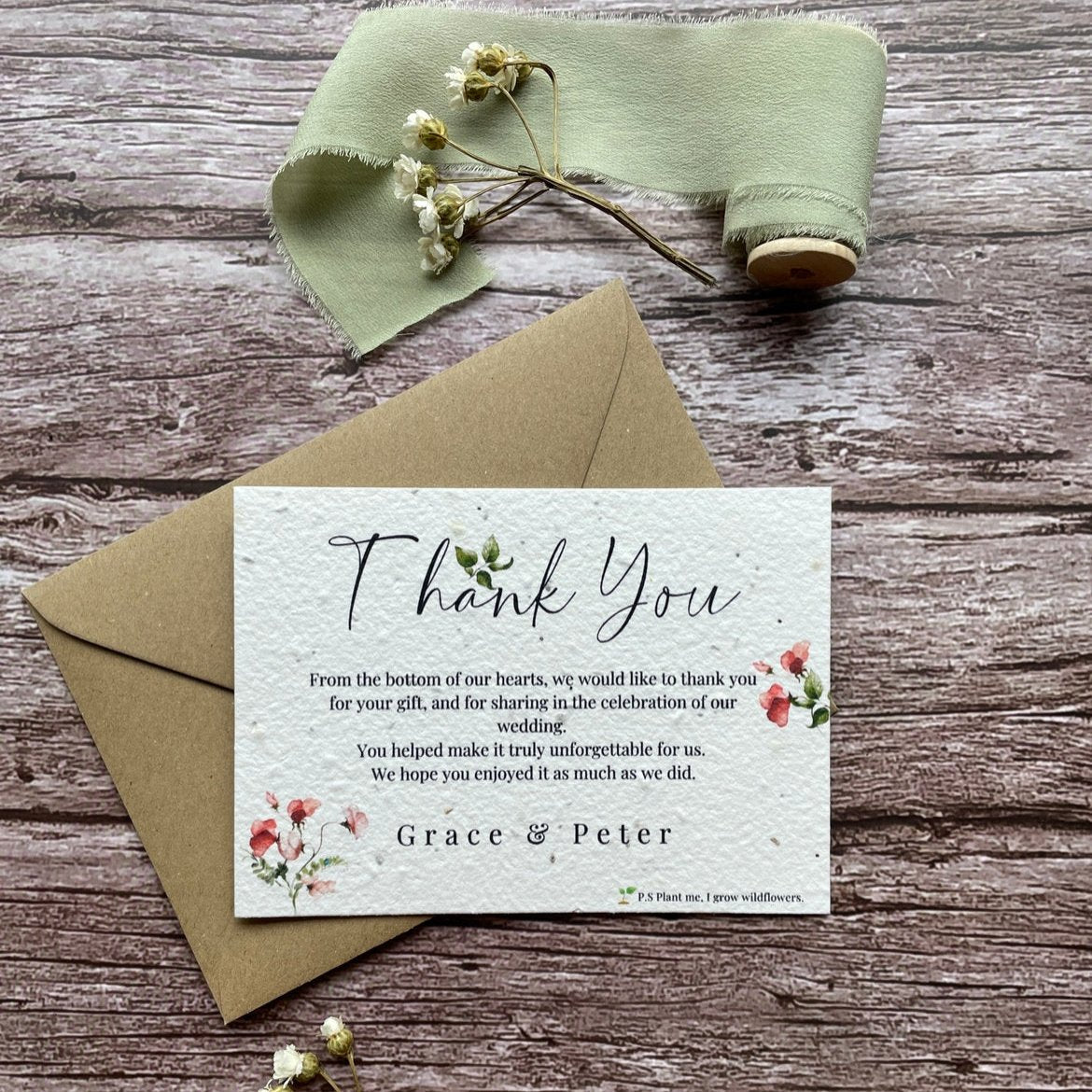 plantable seed paper wedding thank you cards in sweet pea theme, front view with eco-friendly brown kraft envelope, floral design on wooden background