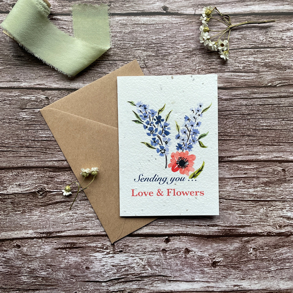 Front view of the 'Sending Love and Flowers - Blue' personalised plantable card featuring a blue floral design. Eco-friendly seed paper card by A La KArt Creations.